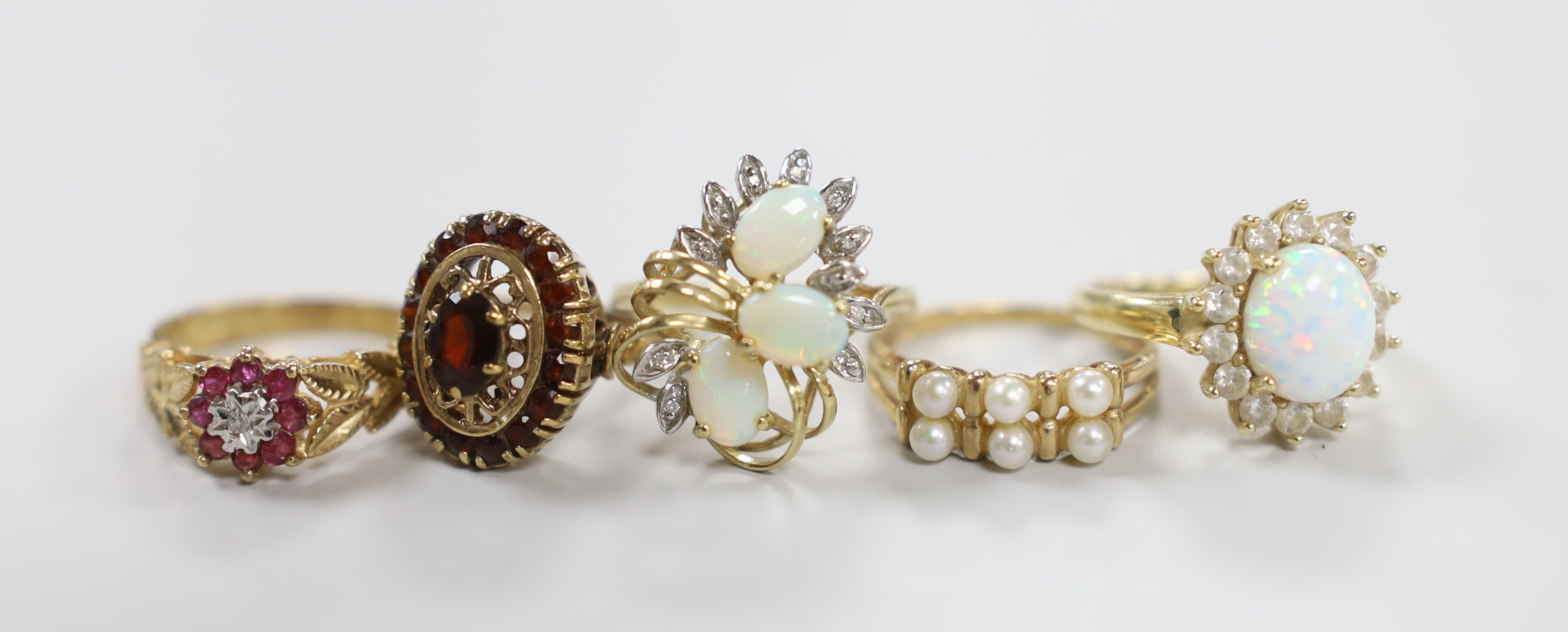 Five assorted modern 9ct gold and gem set dress rings, including garnet cluster, size L, gross weight 17.8 grams.